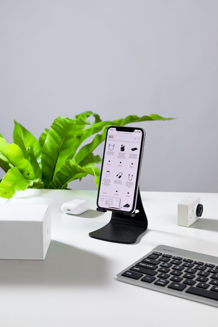 The Art of Drawing Readers In: Your attractive post title goes here A smartphone on a stand with a keyboard and accessories on a white desk.